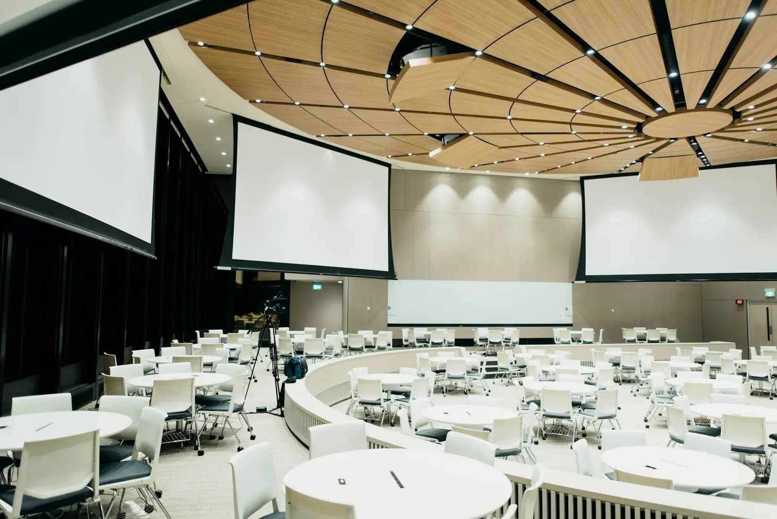 Conference hall set with round tables and screens